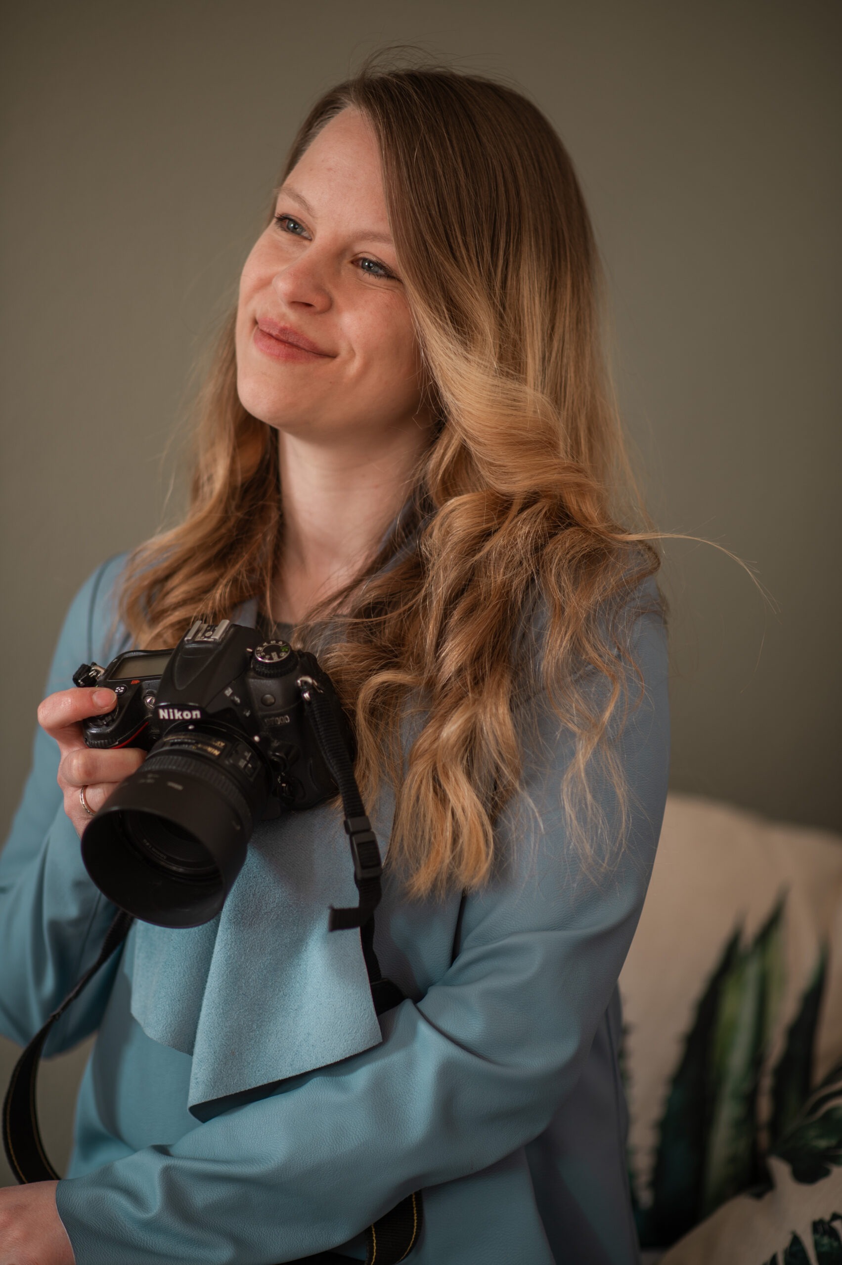Portrait von der Hunde Fotografin Melanie Dulat mit Kamera in der Hand und lächelnd nach links schauend